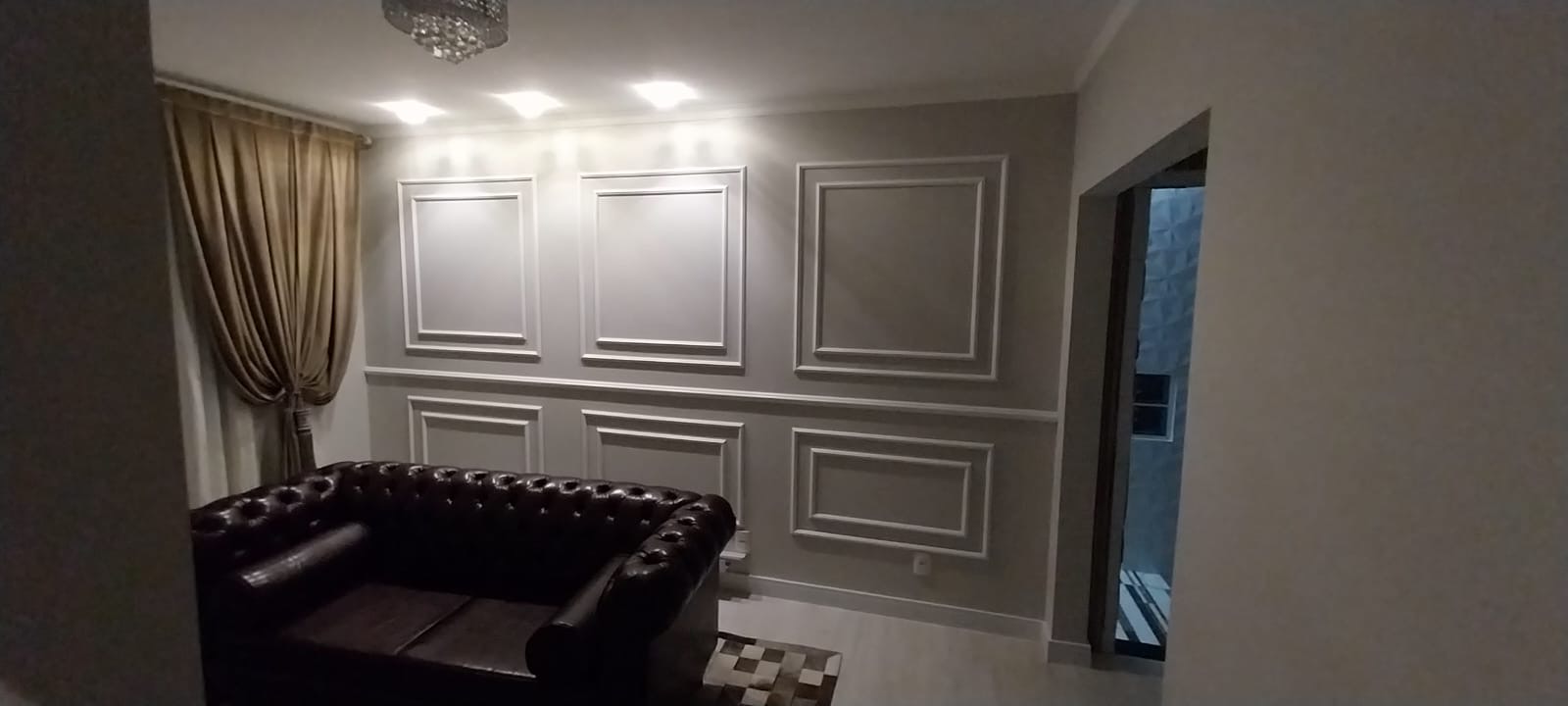 Sala com boiserie clássica e iluminação embutida