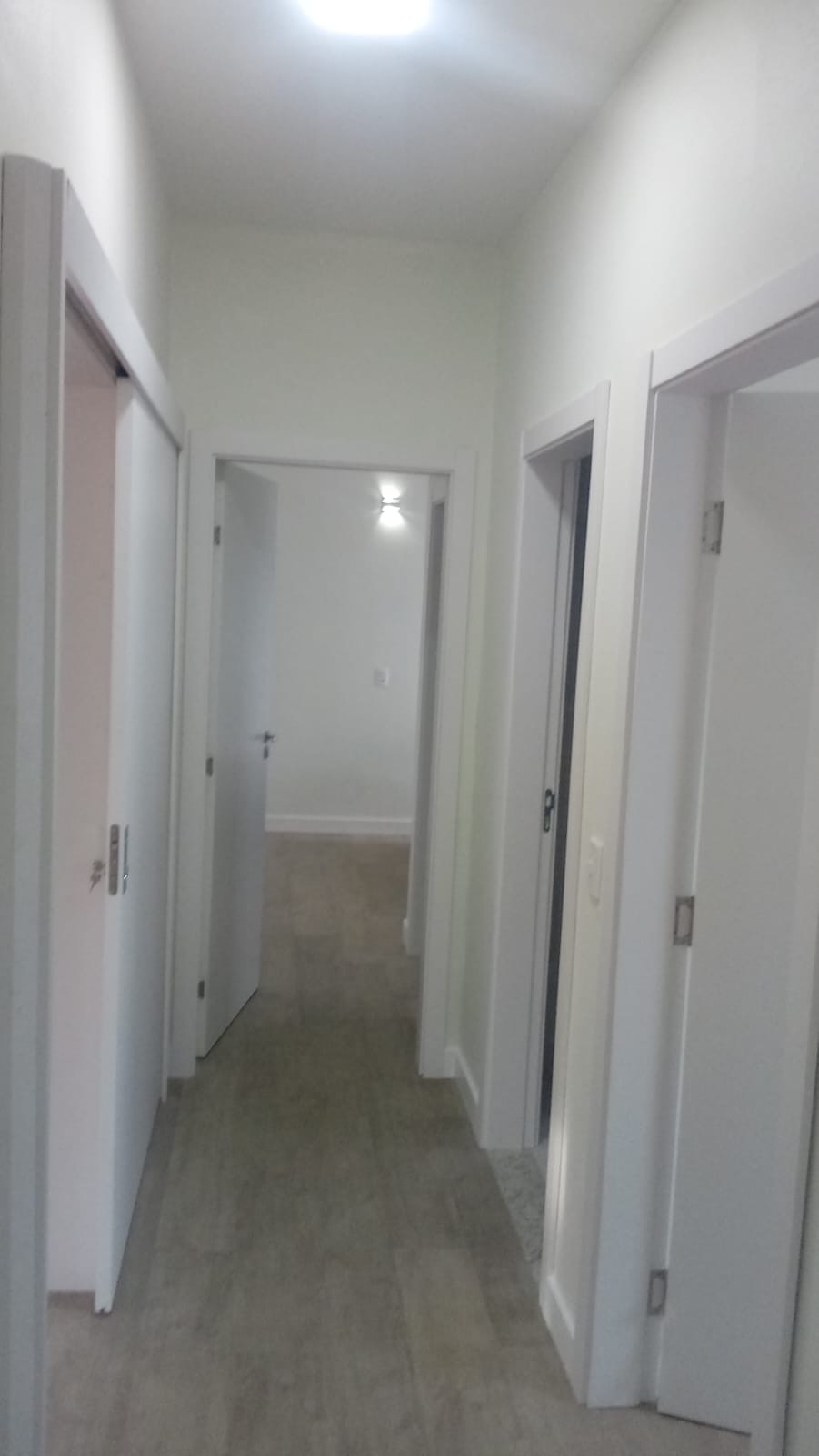 Corredor com portas, batentes e rodapés instalados